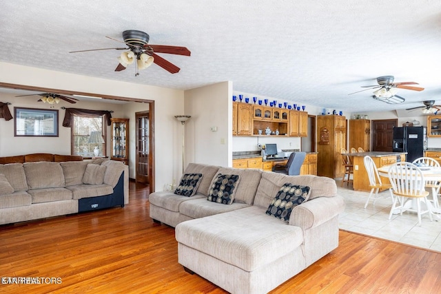 living area with a textured ceiling, light wood-style flooring, and built in desk