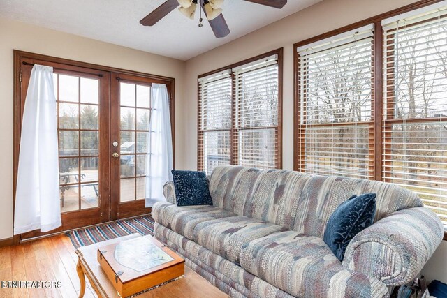 living area featuring french doors, ceiling fan, and wood finished floors