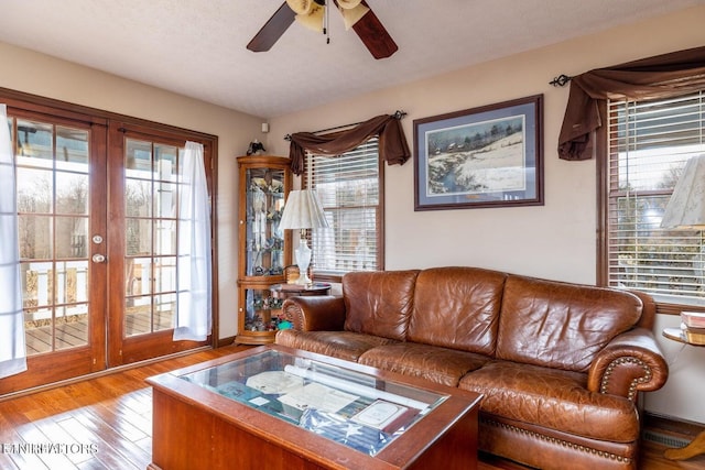 living room with a wealth of natural light, french doors, a ceiling fan, and wood-type flooring