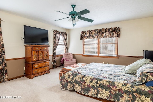 carpeted bedroom featuring baseboards and ceiling fan