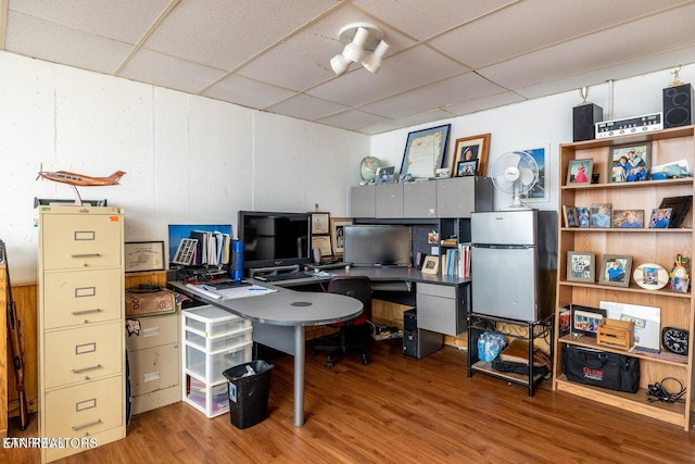 office space with wood finished floors and a drop ceiling