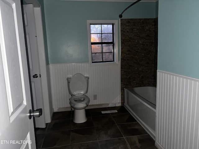 full bathroom with visible vents, a wainscoted wall,  shower combination, tile patterned flooring, and toilet