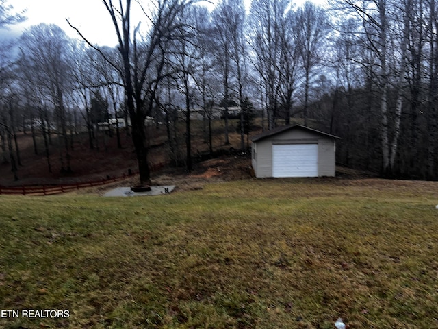 view of yard with a detached garage and an outbuilding