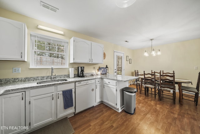 kitchen featuring visible vents, dishwasher, a peninsula, white cabinets, and a sink