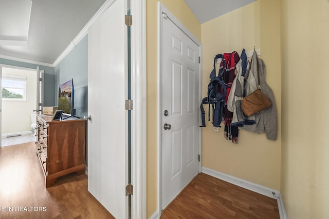 corridor featuring visible vents, baseboards, wood finished floors, and crown molding