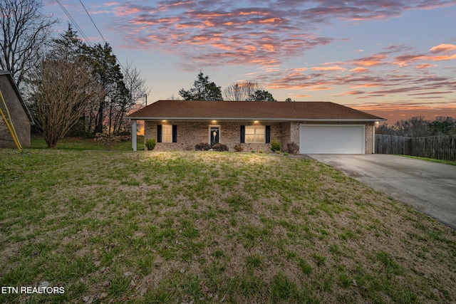 ranch-style house with fence, driveway, a garage, a lawn, and brick siding