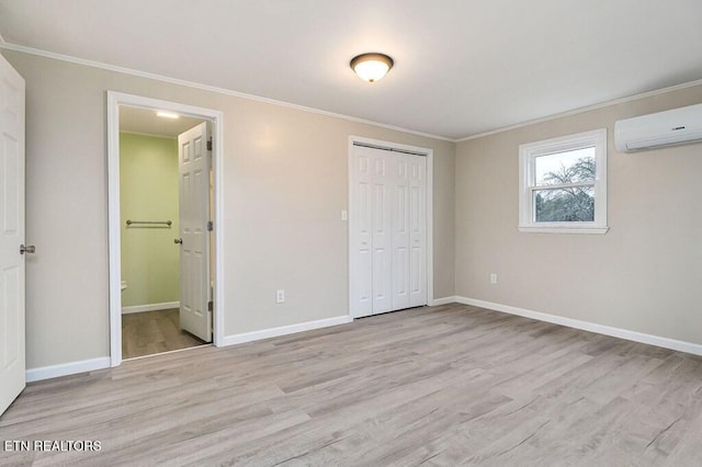 unfurnished bedroom featuring ornamental molding, baseboards, light wood finished floors, and a wall mounted AC