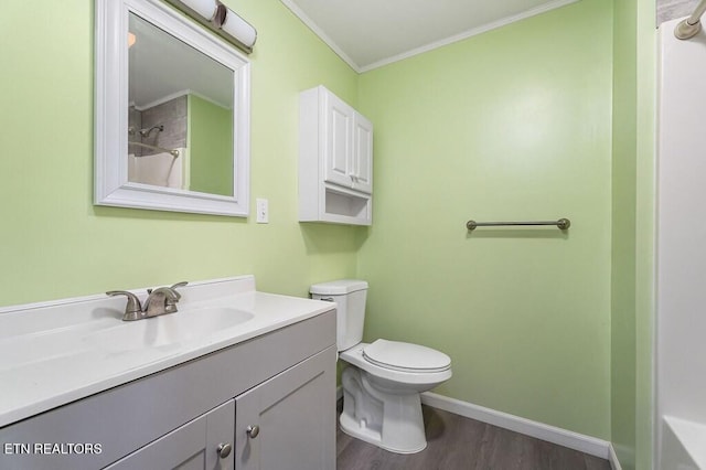 bathroom with vanity, wood finished floors, baseboards, ornamental molding, and toilet