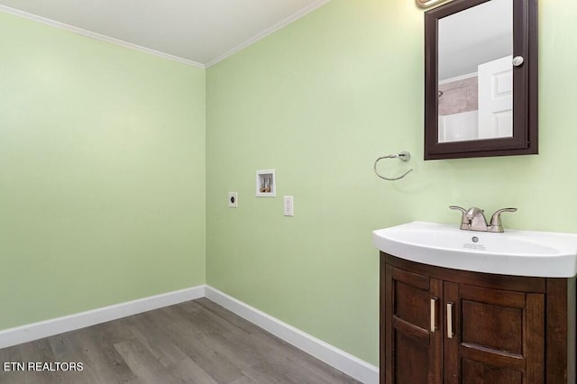 bathroom with ornamental molding, vanity, baseboards, and wood finished floors