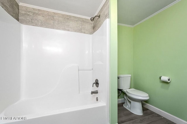 bathroom with toilet, ornamental molding, wood finished floors, baseboards, and shower / bathtub combination