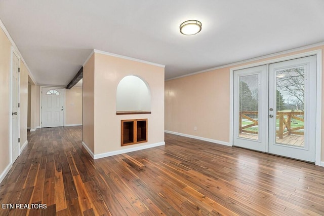 unfurnished living room featuring baseboards, wood-type flooring, a fireplace, and crown molding