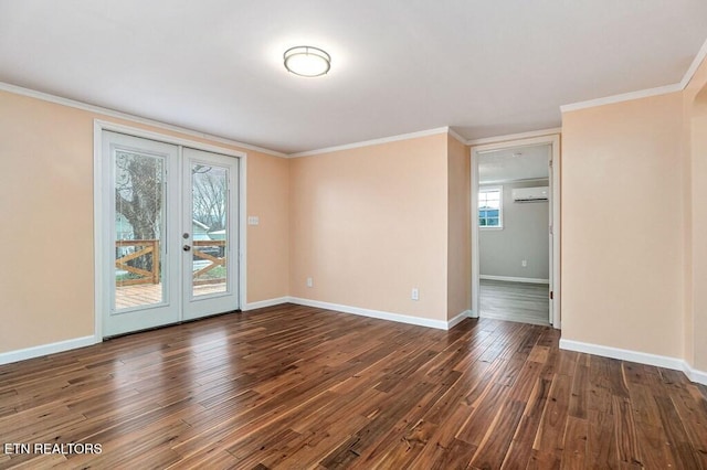 spare room featuring a wall mounted AC, baseboards, and hardwood / wood-style flooring