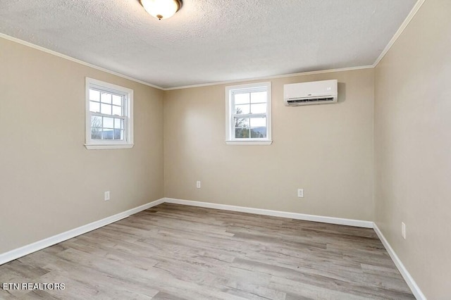 unfurnished room featuring an AC wall unit, wood finished floors, and a healthy amount of sunlight