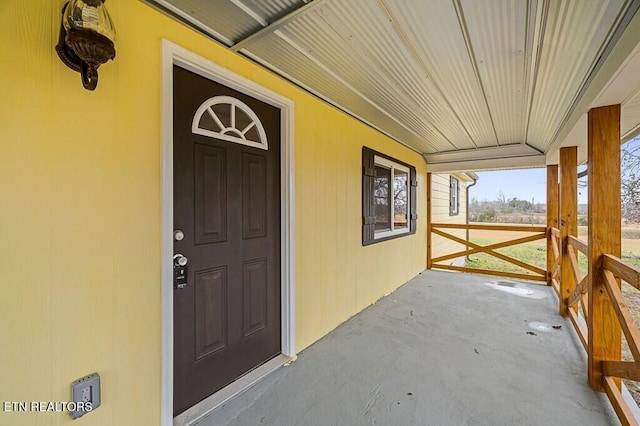 view of exterior entry featuring covered porch