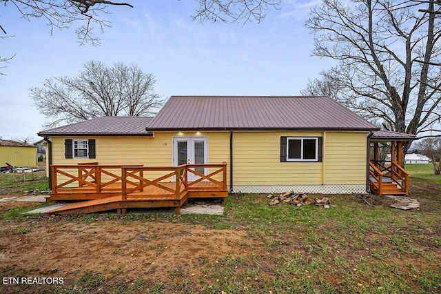 rear view of property featuring a wooden deck, french doors, and metal roof