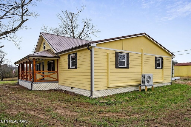 view of side of home with ac unit, metal roof, and crawl space