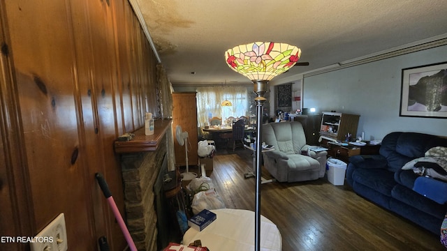 living area with ornamental molding, a textured ceiling, and hardwood / wood-style flooring