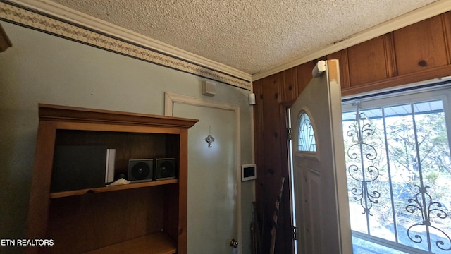 foyer featuring a textured ceiling and crown molding