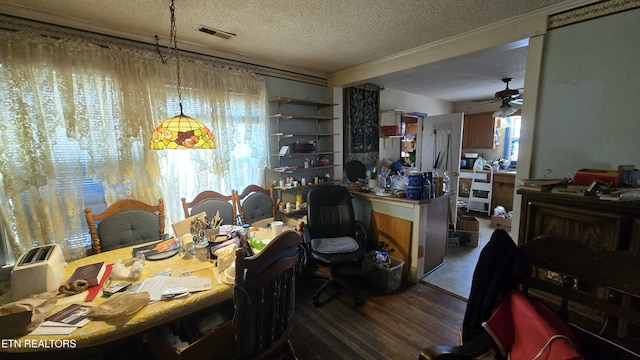 dining room featuring visible vents, wood finished floors, a textured ceiling, and ceiling fan