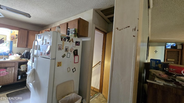 kitchen featuring freestanding refrigerator and a textured ceiling