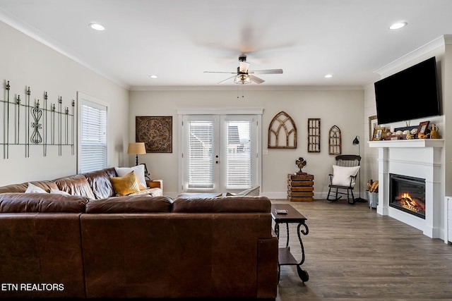 living room with dark wood-type flooring, crown molding, plenty of natural light, and french doors