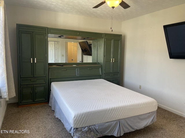 carpeted bedroom with a ceiling fan, baseboards, and a textured ceiling