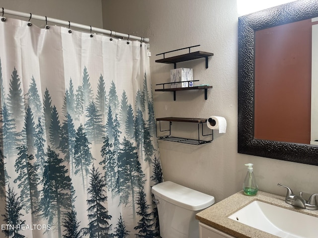 full bath featuring a shower with shower curtain, toilet, vanity, and a textured wall