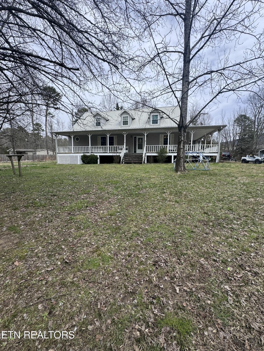 view of front of house with covered porch and a front lawn