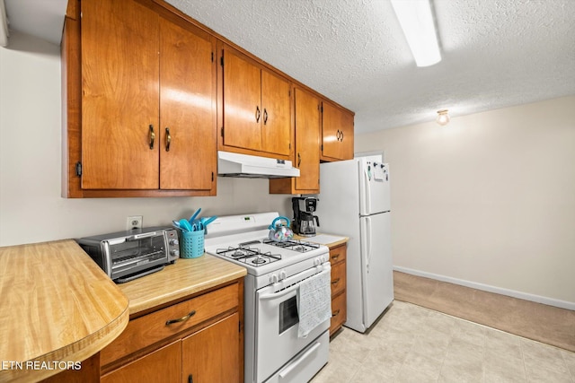 kitchen with under cabinet range hood, a toaster, light countertops, brown cabinetry, and white appliances