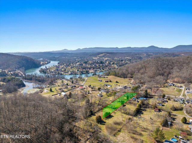 bird's eye view featuring a view of trees and a water and mountain view