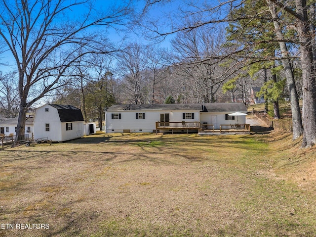 back of property featuring fence, a lawn, an outdoor structure, a deck, and crawl space