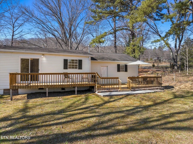 rear view of property with crawl space, a yard, and a wooden deck