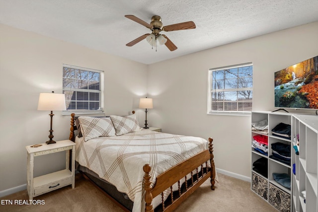 bedroom featuring baseboards, a textured ceiling, carpet, and a ceiling fan