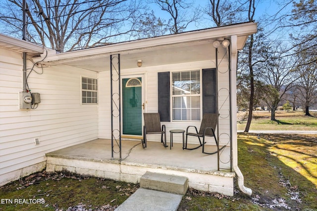 property entrance featuring covered porch and a yard