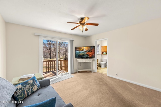 living area featuring baseboards, carpet, and a ceiling fan