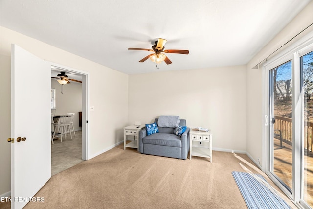 living area with carpet flooring, a ceiling fan, and baseboards