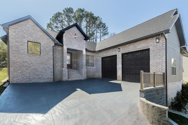 view of front of home featuring a garage, brick siding, driveway, and a shingled roof