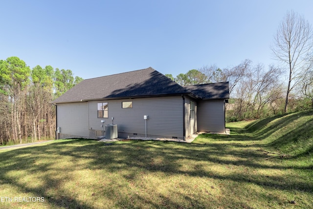 rear view of house featuring crawl space, central air condition unit, a lawn, and roof with shingles