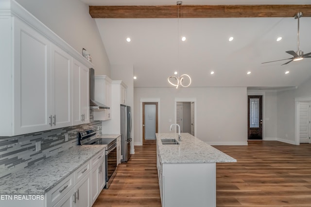 kitchen with beamed ceiling, a sink, wood finished floors, open floor plan, and appliances with stainless steel finishes