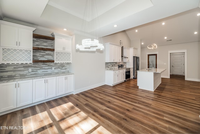 kitchen with white cabinets, stainless steel appliances, a raised ceiling, and a sink