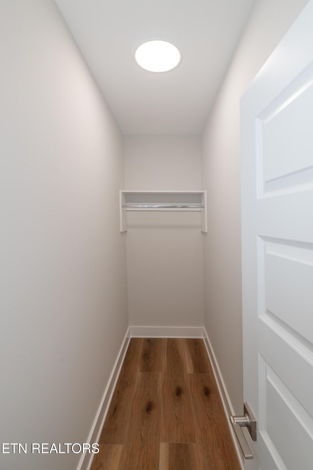 interior space featuring baseboards and wood finished floors