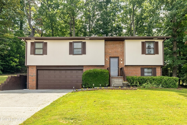 raised ranch with brick siding, a garage, driveway, and a front lawn