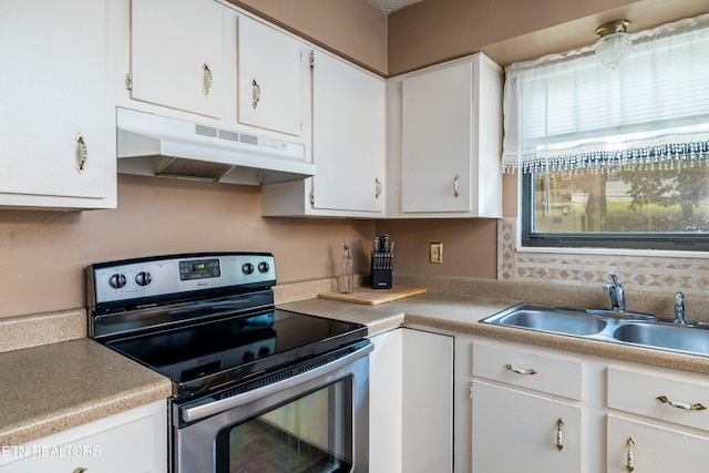 kitchen with stainless steel range with electric stovetop, white cabinets, under cabinet range hood, and a sink