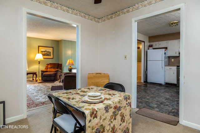 dining space with baseboards, carpet floors, and a textured ceiling