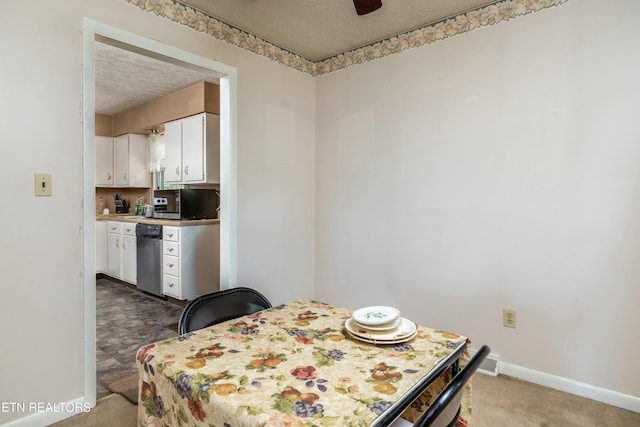 carpeted dining area with baseboards and a textured ceiling