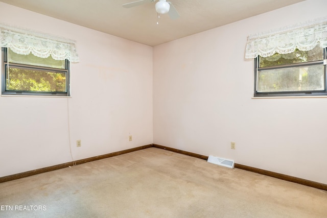 carpeted empty room featuring a ceiling fan, baseboards, and visible vents