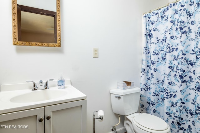 bathroom with curtained shower, toilet, and vanity