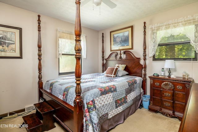 carpeted bedroom featuring a textured ceiling and ceiling fan