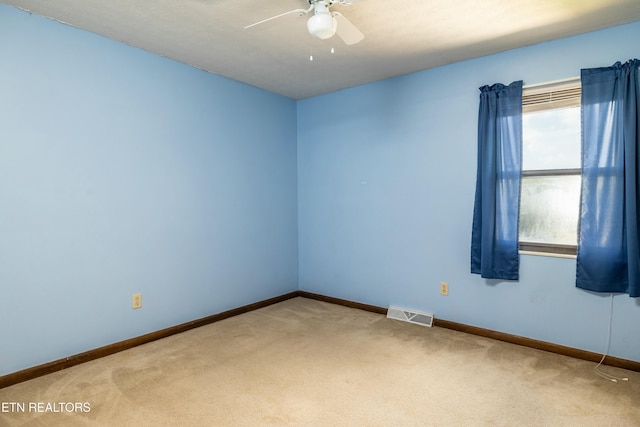 unfurnished room with visible vents, carpet floors, baseboards, and a ceiling fan