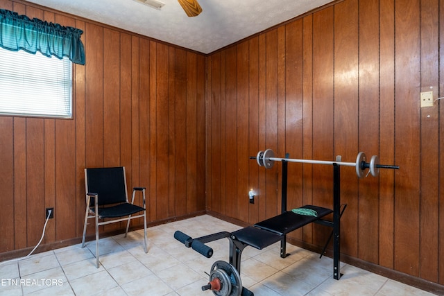 workout area featuring wood walls and ceiling fan